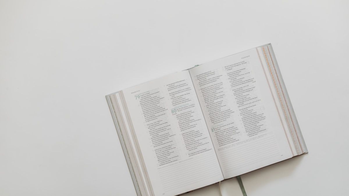 白い机に開かれた本のページ。書かれた言葉から話題を読み取るイメージ