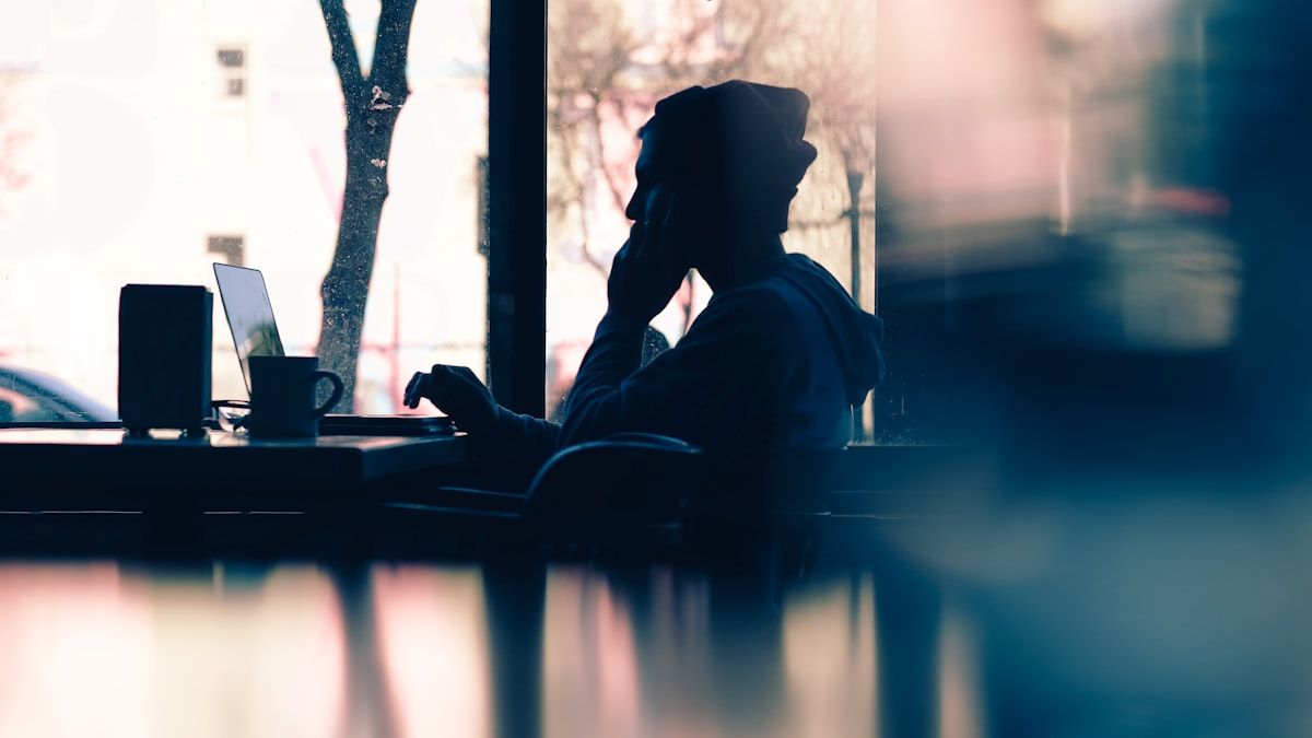 カフェで記事を読み次の行動を考える読者のシルエット