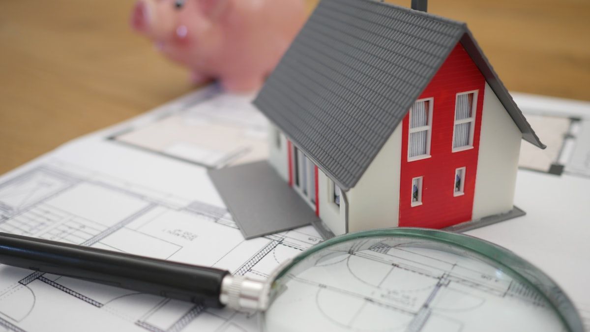 住宅模型と図面を前に不動産記事の情報の正確さを確認する様子