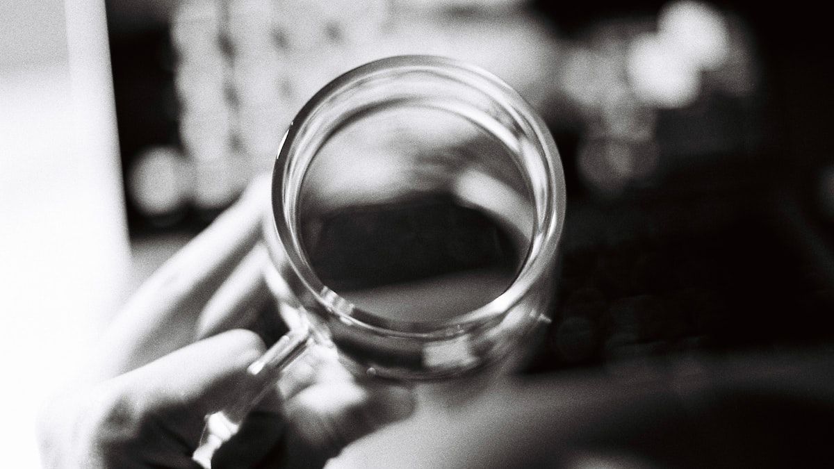 虫眼鏡を手に持ち、同じ道具でも見え方が変わることを示したイメージ