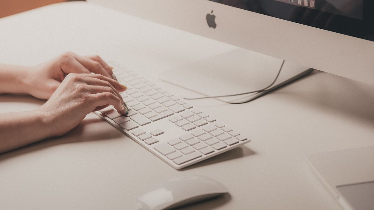 デスクのキーボードで入力する手元。サーチコンソールでクエリを調べる場面のイメージ