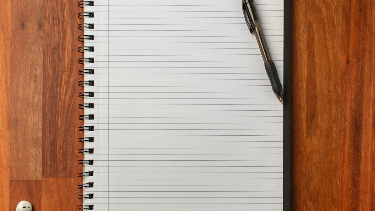 SEOキーワードを書き出すために机に開いたノートとペン