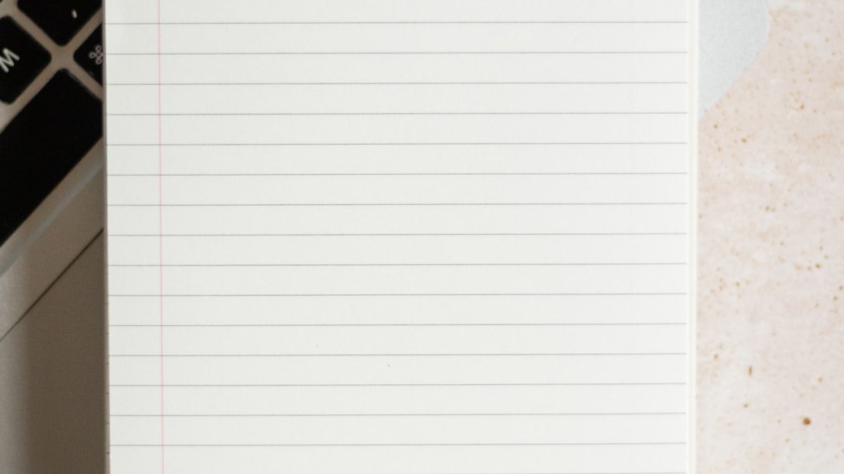 書いた説明文がGoogleに書き直される様子を表すキーボードと白紙のメモ帳