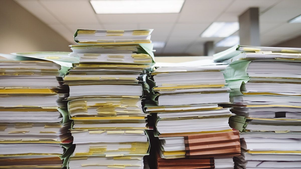 勘定科目ごとの仕分けを待つ、オフィスに積み上がった経理書類の束