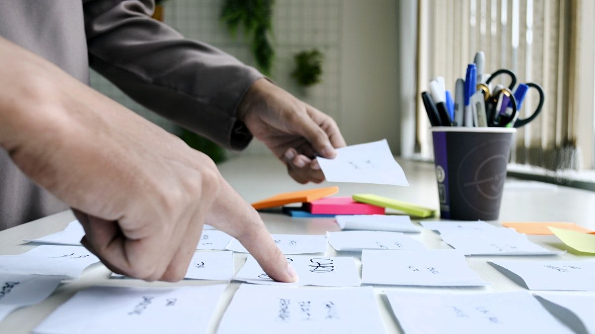 コンテンツの範囲を線引きする場面。白い紙に手書きで書き込んでいる手元
