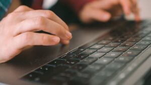 ノートパソコンのキーボードを打つ手元。LLMを使って仕事を進める様子